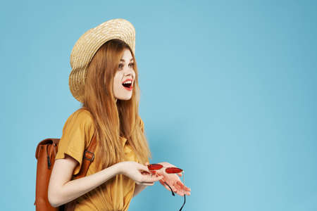 Woman with hat fashionable clothes backpack fun blue background smile
