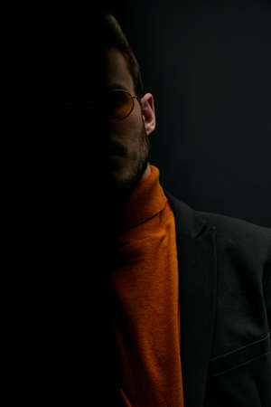 silhouette of a man in a sweater and jacket on a black background falling shadowの写真素材