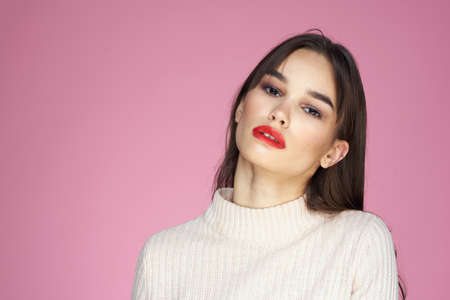 Beautiful brunette red lips white blouse close-up attractive view pink backgroundの写真素材