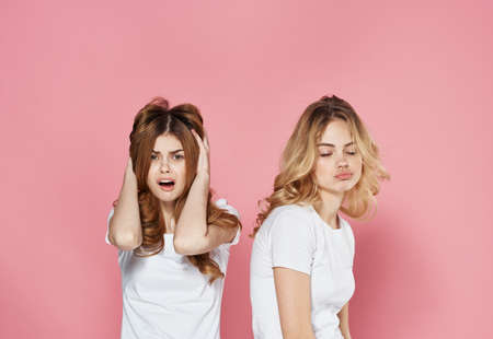 two women in t-shirts fashion glamor communication emotions pink backgroundの写真素材