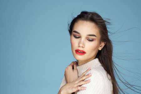 Brunette in white sweater red lips charm cropped view blue background