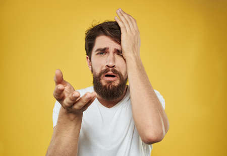 Emotions model irritability sad face yellow background manの写真素材