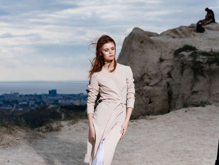 A woman in light clothes in the mountains in nature and high rocksの写真素材