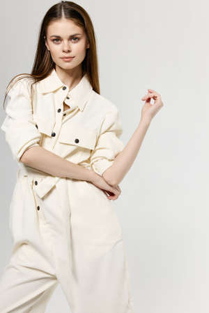 portrait of woman in jumpsuit pastel colors gesturing with hands fashion styleの写真素材