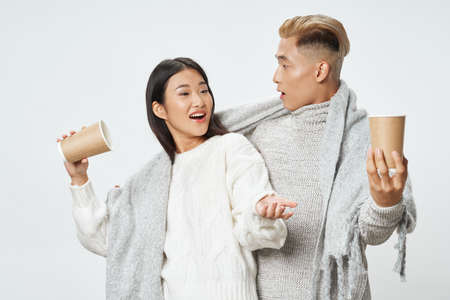 young asian couple with plaid warming drink fashionの写真素材