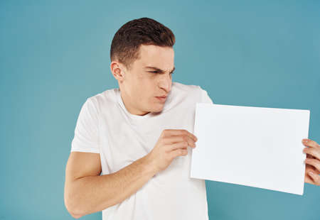 Guy with a white sheet of paper blue background advertising mocap posterの写真素材