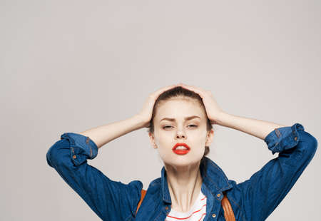 beautiful woman with backpack clothing model student gray backgroundの写真素材