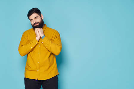 a man with a beard in a yellow shirt on a blue background Copy Spaceの写真素材