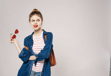 Cheerful young woman in fashion clothes backpack student teaching teenager gray background