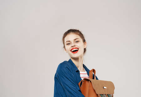 beautiful cheerful woman with backpack student training clothes fashion gray backgroundの写真素材