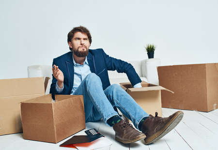 Business man picking up cardboard boxes and moving to a new place lifestyleの写真素材