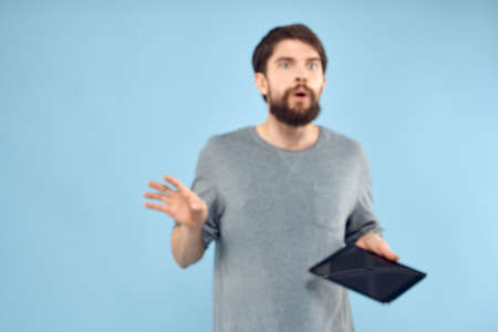 A man holding a tablet in the hands of a wireless device internet technology blue backgroundの写真素材