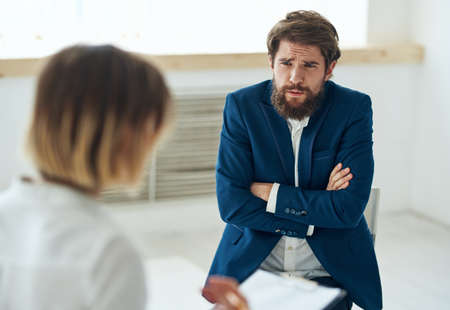 Emotional man at the reception of a psychologist consultation diagnosis of the problem treatmentの写真素材