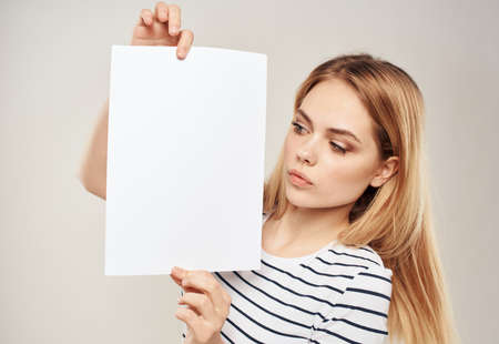 Blonde woman with a white sheet of paper in the hands of an advertising banner