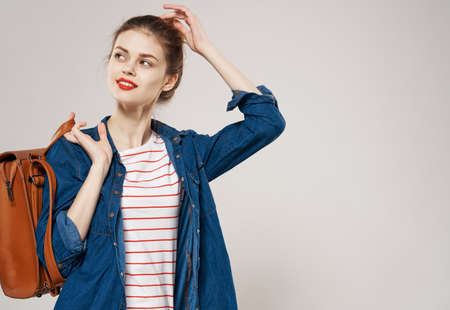 beautiful cheerful woman with backpack student training clothes fashion gray backgroundの写真素材