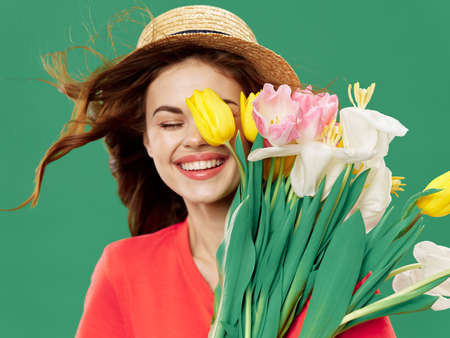 woman with flowers on a green background spring 8 march holidays modelの写真素材
