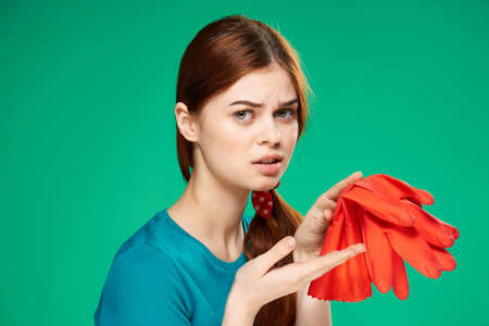 cheerful cleaning lady rubber red gloves in the hands of a professional Green backgroundの写真素材