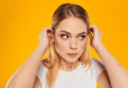 Beautiful woman White T-shirt on yellow background smiling close-up cropped viewの写真素材