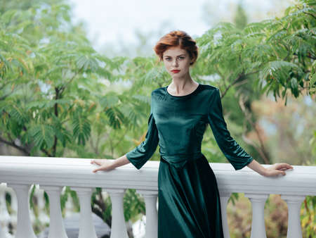 Attractive woman in luxury green dress green leaves nature romance architectureの写真素材