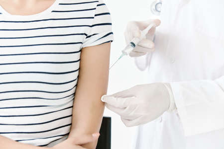 Injection of vaccine into shoulder in hospital close-upの写真素材