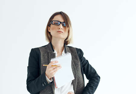 Cropped view of a business woman in a classic suit with documents on a light backgroundの写真素材