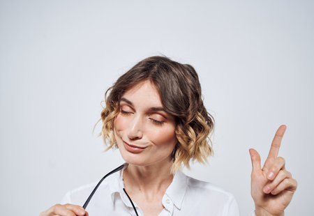 Woman wearing glasses with curly hair white shirt Copy Spaceの写真素材