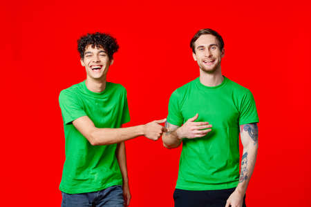 Happy friends in green t-shirts with emotions communication studioの写真素材