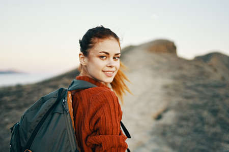 happy travel with backpack woman climbs to the top of the mountains along the pathの写真素材