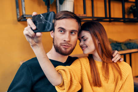 woman with mobile phone and happy man friends fun family communication interior