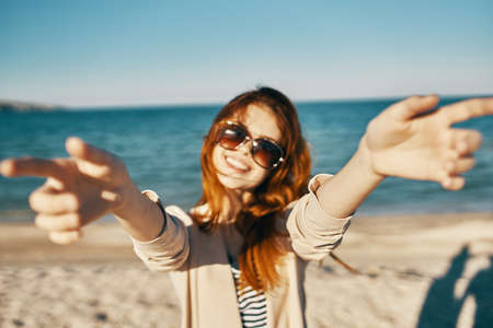 portrait of red-haired woman with glasses near the sea in the mountains on the beach cropped viewの写真素材