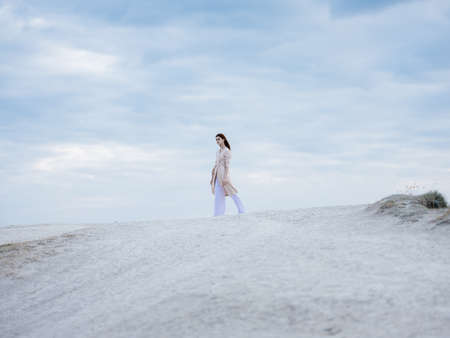 traveler woman on the sand in the mountains clouds blue sky nature fresh air