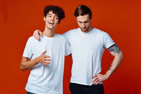Two cheerful friends in white t-shirts stand side by sideの写真素材