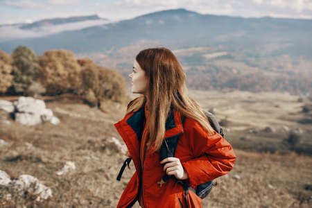 woman hiker in a jacket and with a backpack are resting in the mountains landscape Relax modelの写真素材