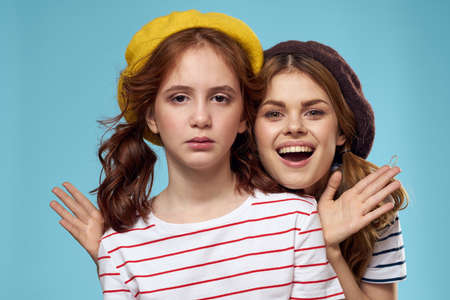 Cheerful mom and little daughter hat fashionable clothes woman joy blue backgroundの写真素材