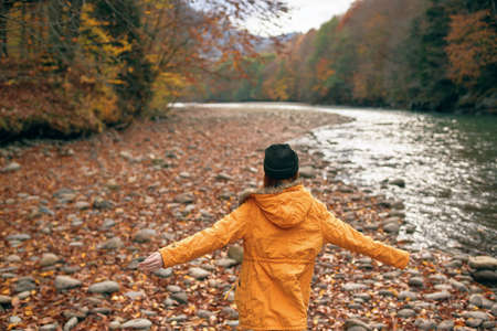 woman walking in the forest along the river autumn travel