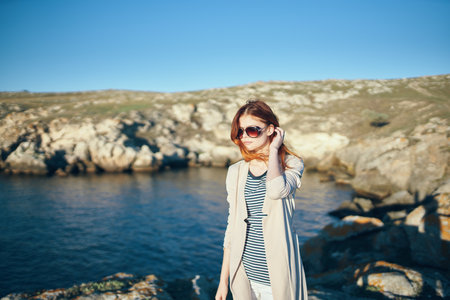 woman travels in the mountains in nature and glasses on her face Blue river sea modelの写真素材