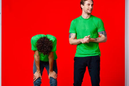 Two cheerful friends in green t-shirts joy of communicationの写真素材