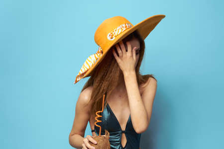 Cheerful woman beach hat exotic fruits swimsuit lifestyle blue background