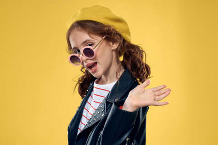 Girl in a yellow hat dark glasses fashionable clothes studio lifestyle childhood