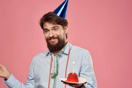 Happy car with a cake on a pink background and in a cap in Copy Space holidays birthdayの写真素材