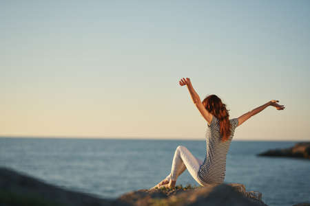 a traveler in the mountains by the sea gestures with her handsの写真素材