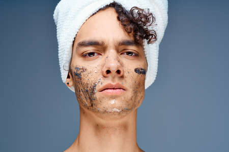 guy with a towel on his head cosmetics skin care close-up