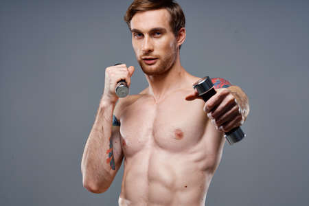 guy with a naked torso pumped up arm muscles dumbbells fitness bodybuilding sports