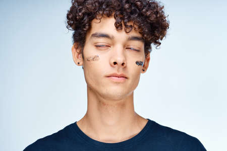 emotional man with curly hair cosmetics skin care close-upの写真素材