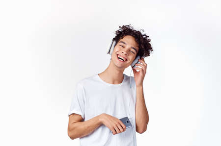 joyful guy in headphones listens to music emotions light background
