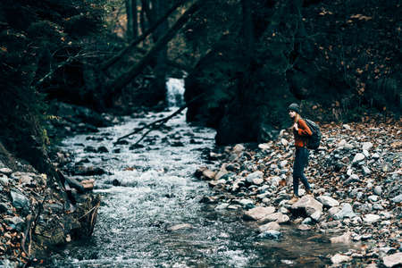 woman in a sweater hat near the river and trees in the backgroundの写真素材