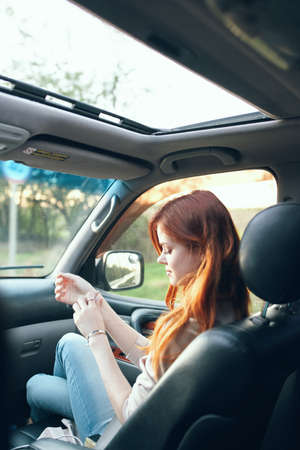 woman with an open window in the front seat of a car gesturing with her hands interior salon fellow...