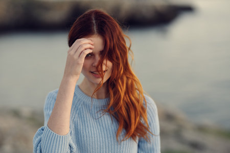 happy traveler in the mountains blue sweater model hairstyle natureの写真素材