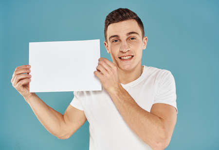 Handsome guy with white sheet of paper advertising mockup Copy Spaceの写真素材