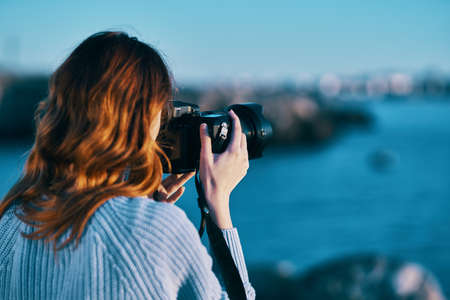woman with camera on nature sea landscapeの写真素材